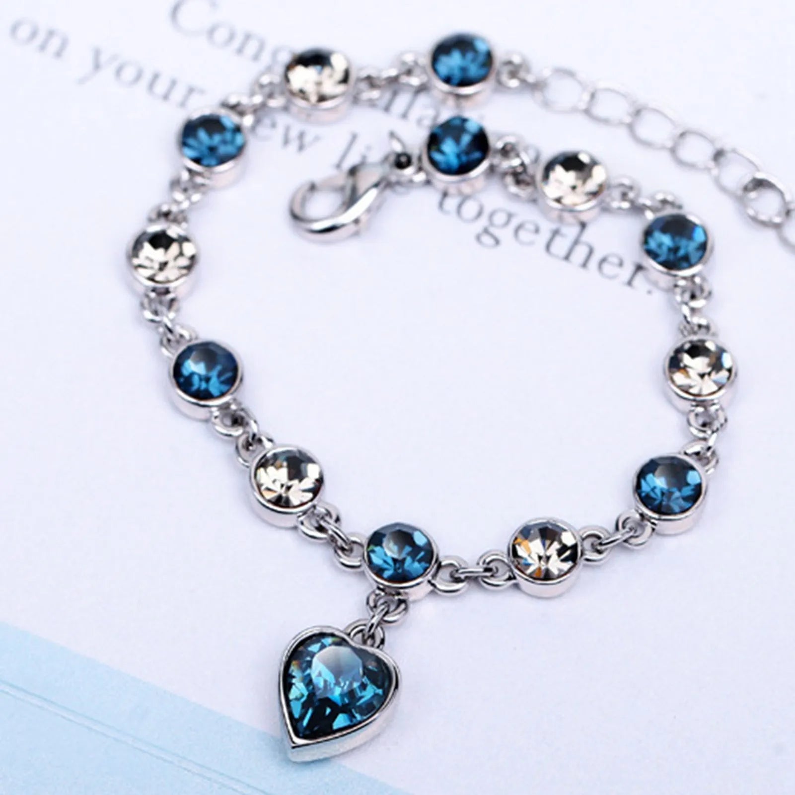 Adjustable sterling silver bracelet featuring azure cubic zirconia stones, designed with an ocean-inspired motif for comfortable wear. 1